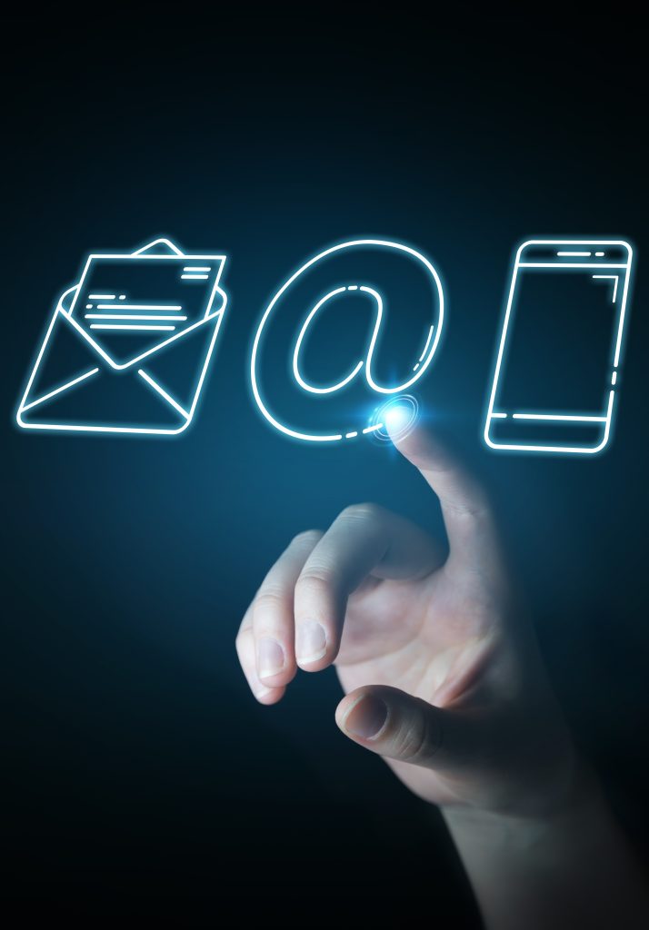 Grafika przedstawiająca rękę z wysuniętym pacem klikające symbole poczty internetowej na ekranie.